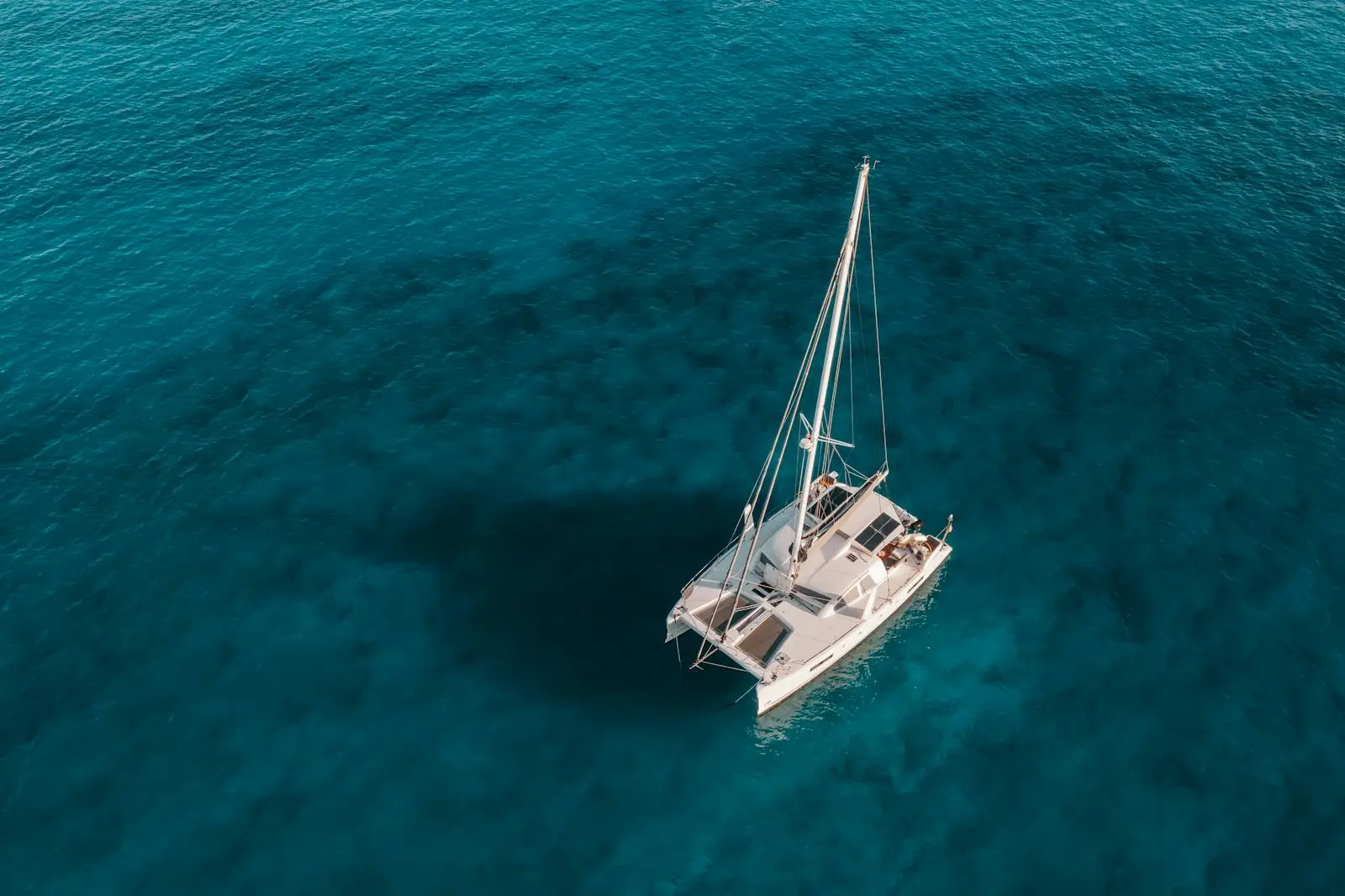 A catamaran anchored off an Ionian beach