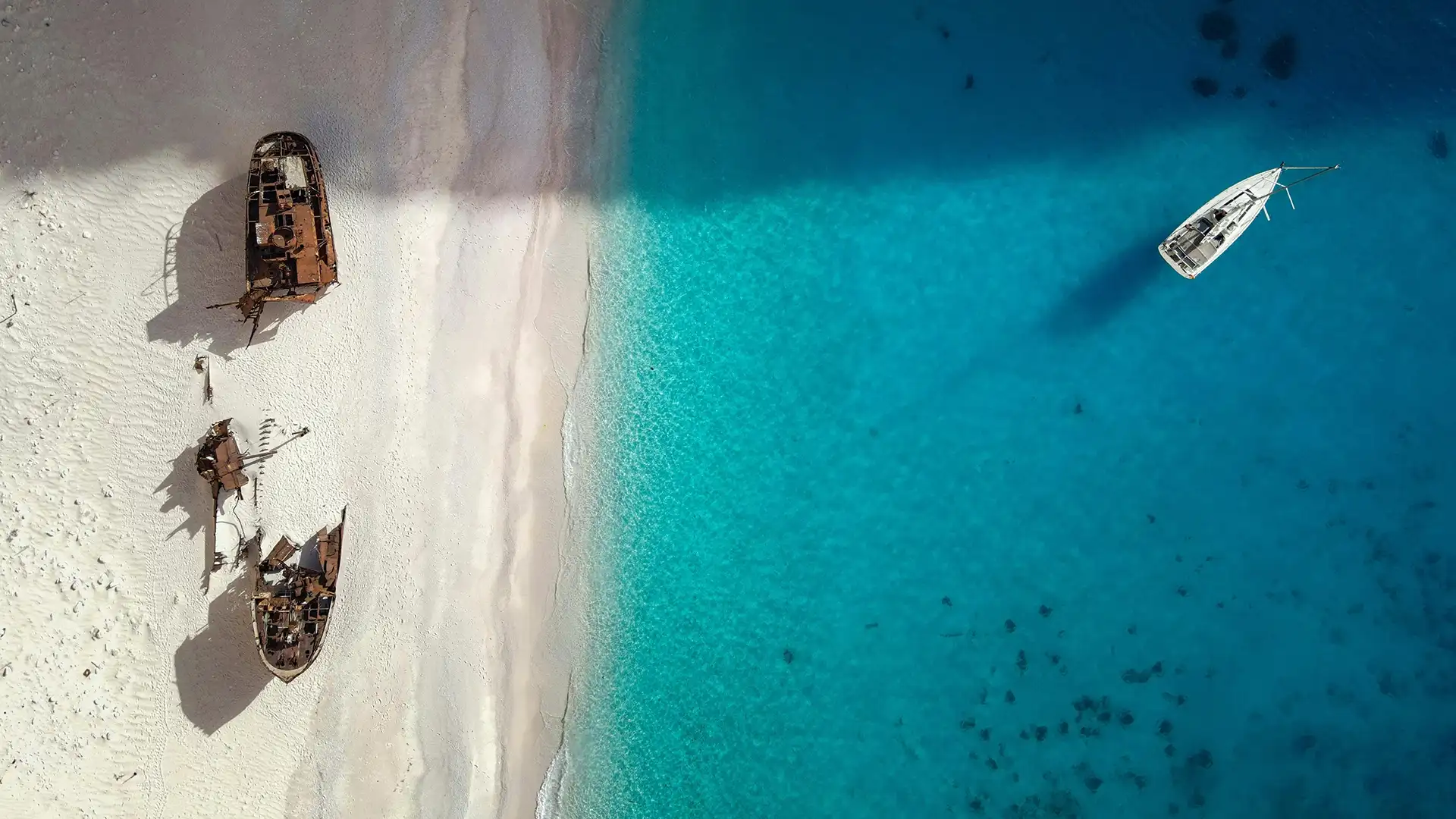 Aerial view of Navagio beach with a sailing yacht on turquoise water