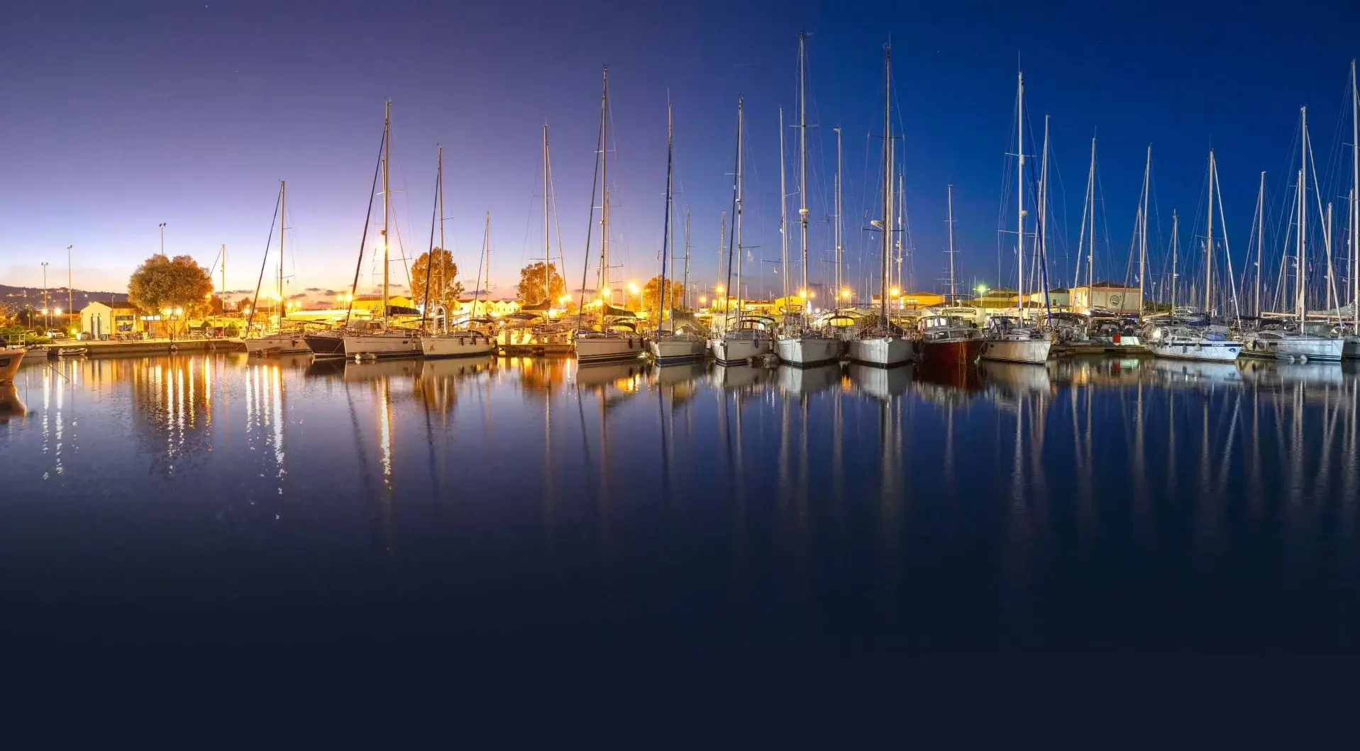 Lefkas Marina at dusk with yachts reflected in still water